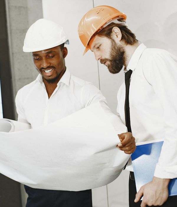 Professional man engineer wearing safety helmet holding architectural plans